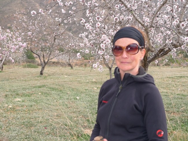 Juanita wandert durch ein Feld mit Mandelbäumen