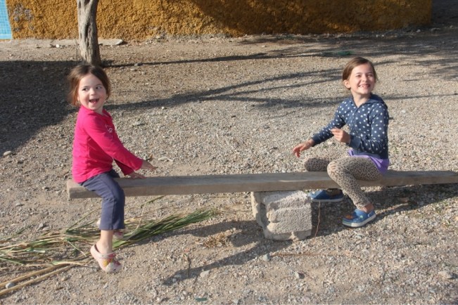 Penelope und Esmeralda probieren die selbstgebastelte Wippe aus